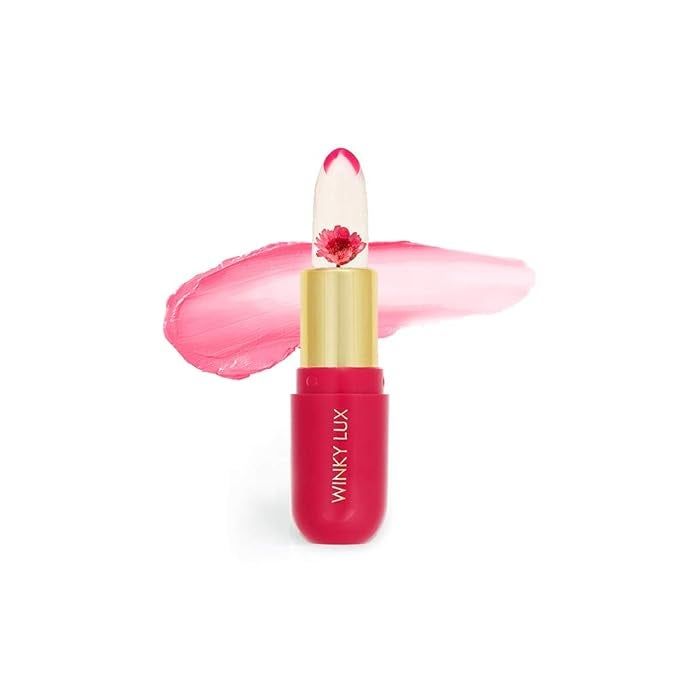 Winky Lux Flower Balm lipstick, featuring a transparent bullet containing a real flower inside. A pink swatch is shown behind the tube.