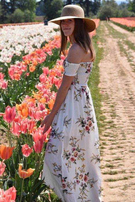 A reviewer wearing the long, off-shoulder, flowing white dress.