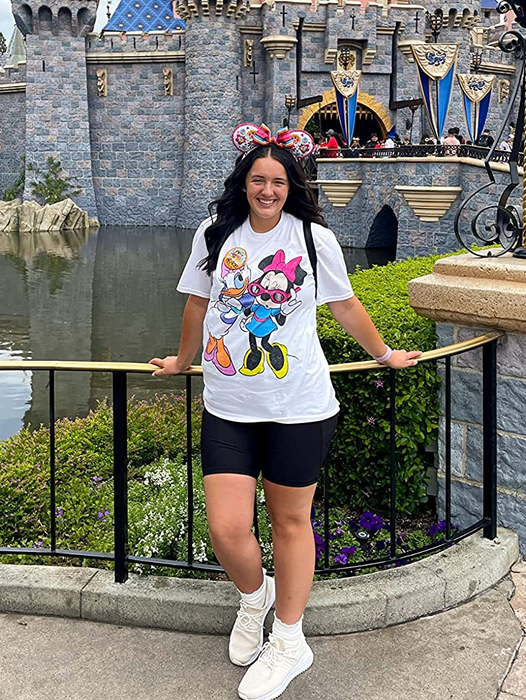 a Disney Land reviewer sporting a white t-shirt with Minnie Mouse and Daisy Duck on it