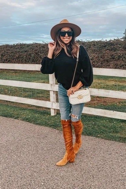 A reviewer dressed in the sweater, showcasing it in black.