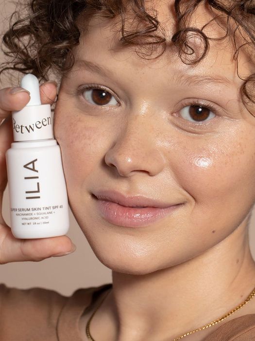 model wearing and holding the skin tint in shade Baikal ST9.5