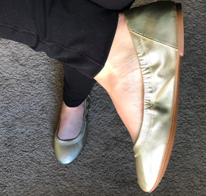 A customer’s review photo of them wearing the shoes in a sleek gold color.