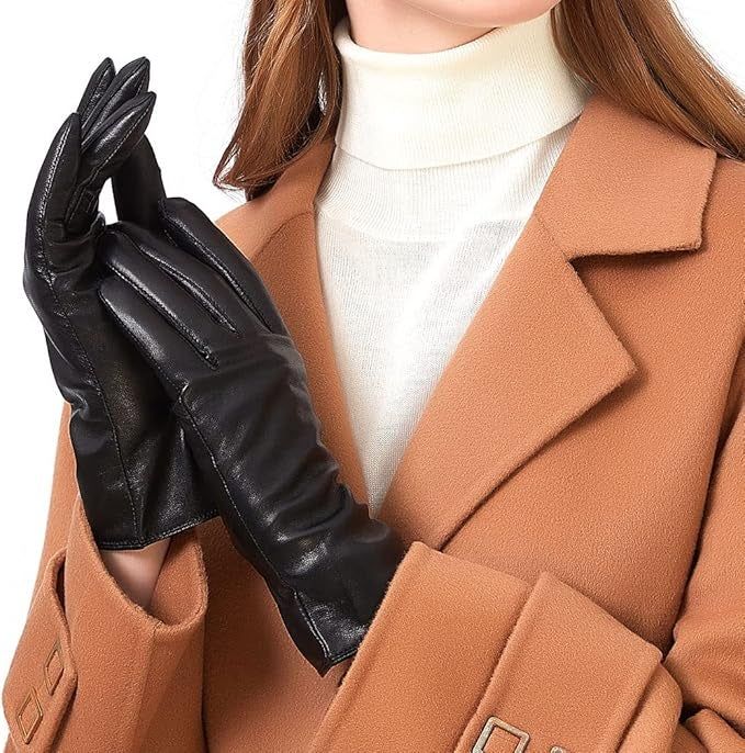 A woman in a camel coat showcasing sleek black leather gloves, perfect for winter fashion