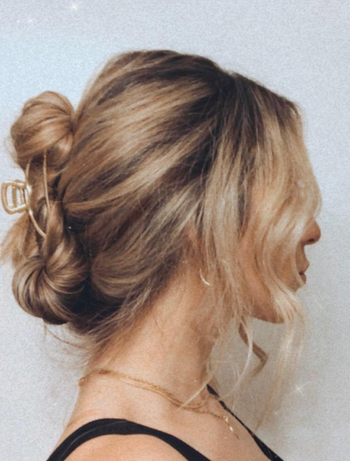 A reviewer with their hair elegantly styled and secured with a gold claw clip at the back