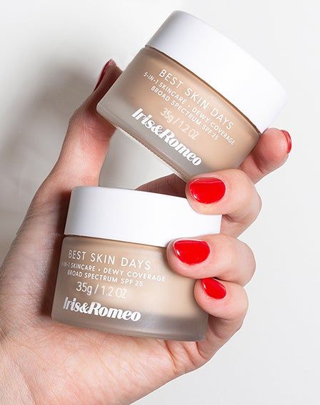 a model holding two containers of the tinted moisturizer