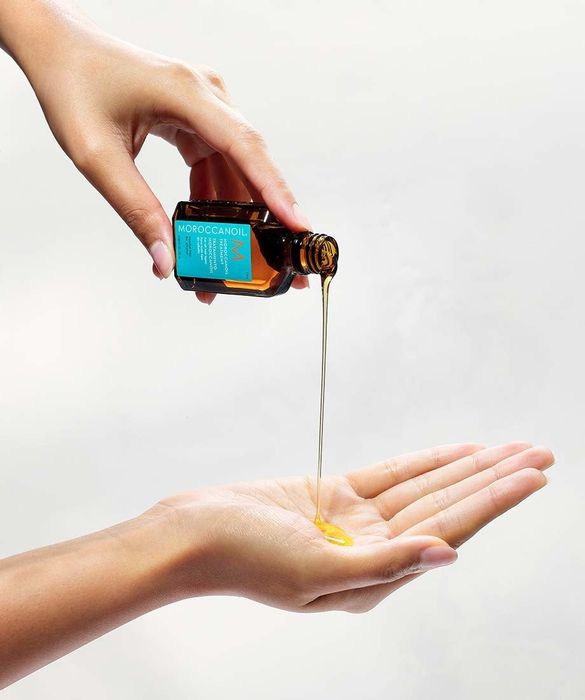 Model pouring Moroccanoil treatment into their hand