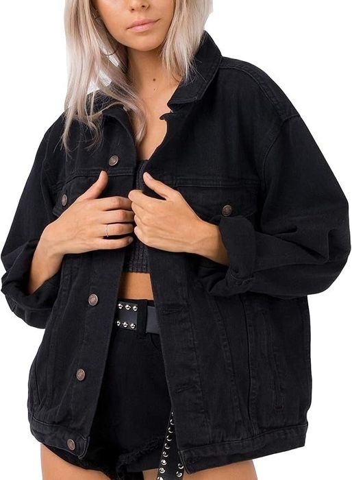 A person rocking an oversized denim jacket paired with matching shorts and a studded belt.