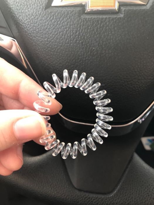 A reviewer is holding one of the hair ties.