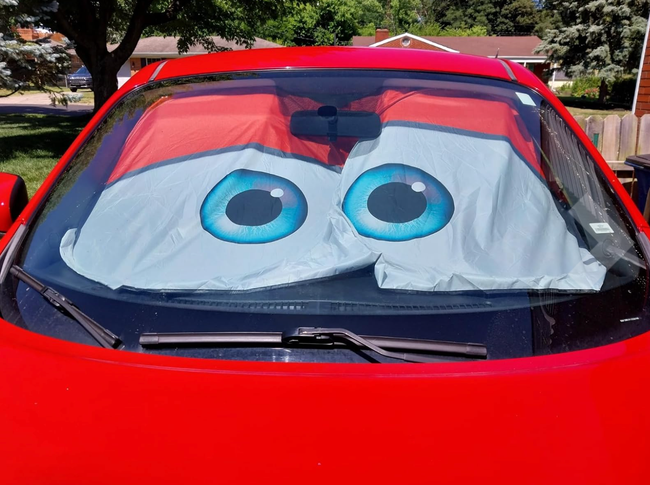 Car windshield sunshade featuring a cartoonish design with large blue eyes