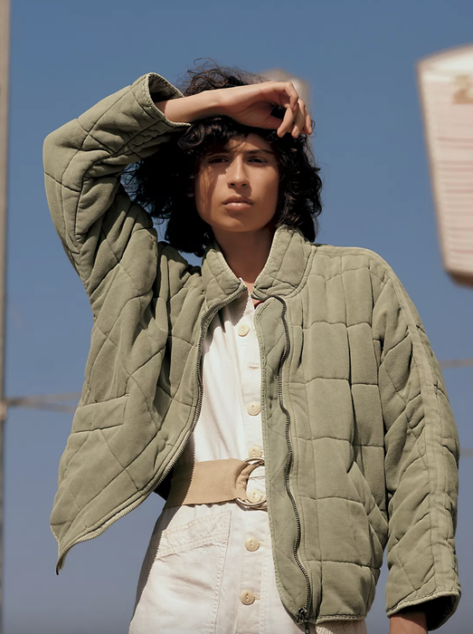 A different model showcasing the coat in olive green.