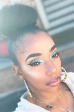 A reviewer with metallic eye makeup showcasing the primer's effect.