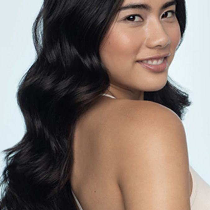 Model with smooth waves and curls after using the same curl enhancer on their long hair