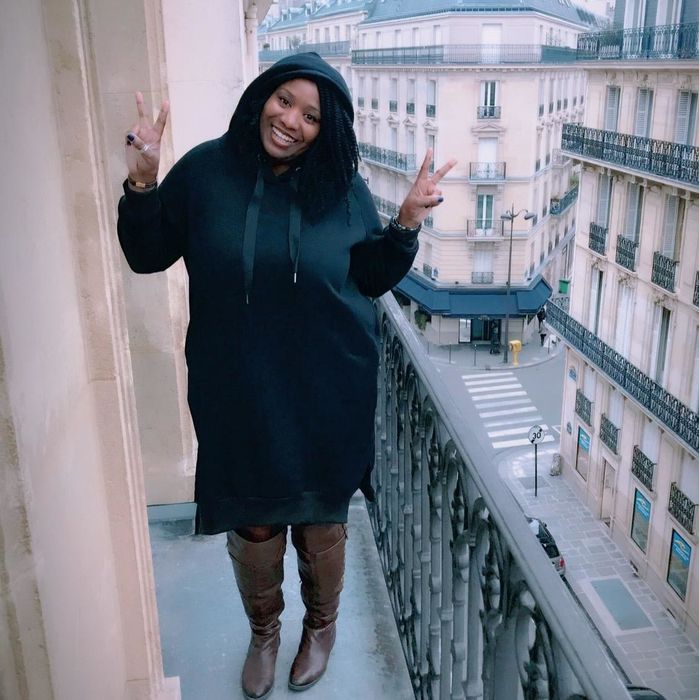 A reviewer wearing the knee-length hoodie dress in sleek black.