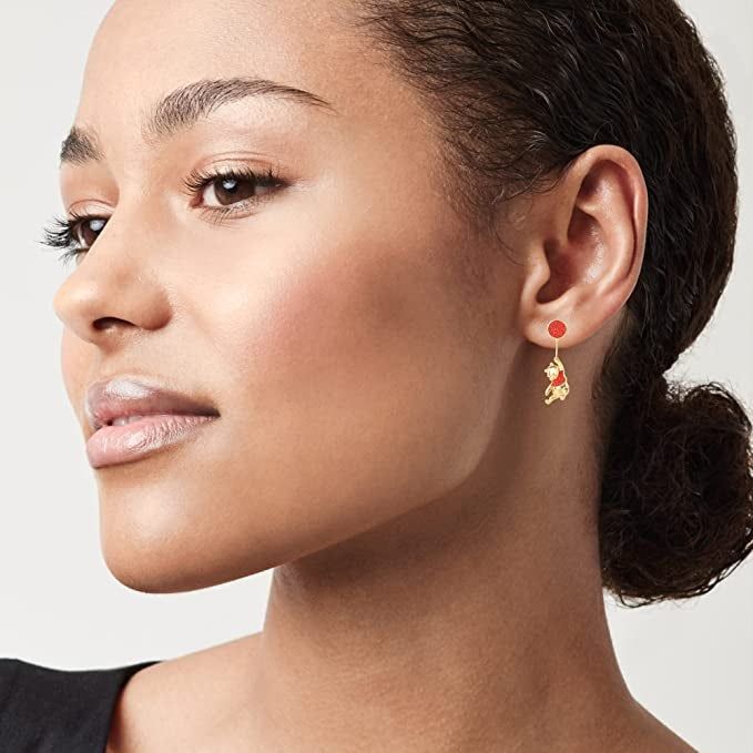 a model showcasing gold Winnie the Pooh drop earrings