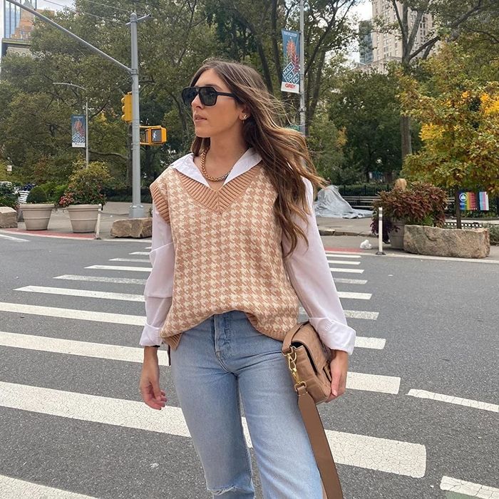 A reviewer is shown wearing the vest in a neutral khaki shade.