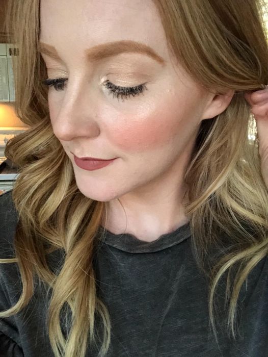 A reviewer applying the bronzer to their skin, resulting in a fresh, flushed look.