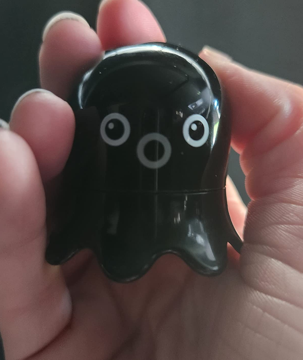 A reviewer holding the scrub stick shaped like an octopus