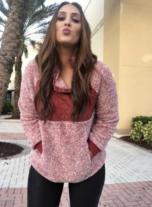 A reviewer is pictured wearing the pullover in a deep burgundy color.