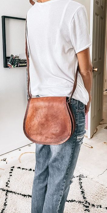 A reviewer models the cross-body bag.