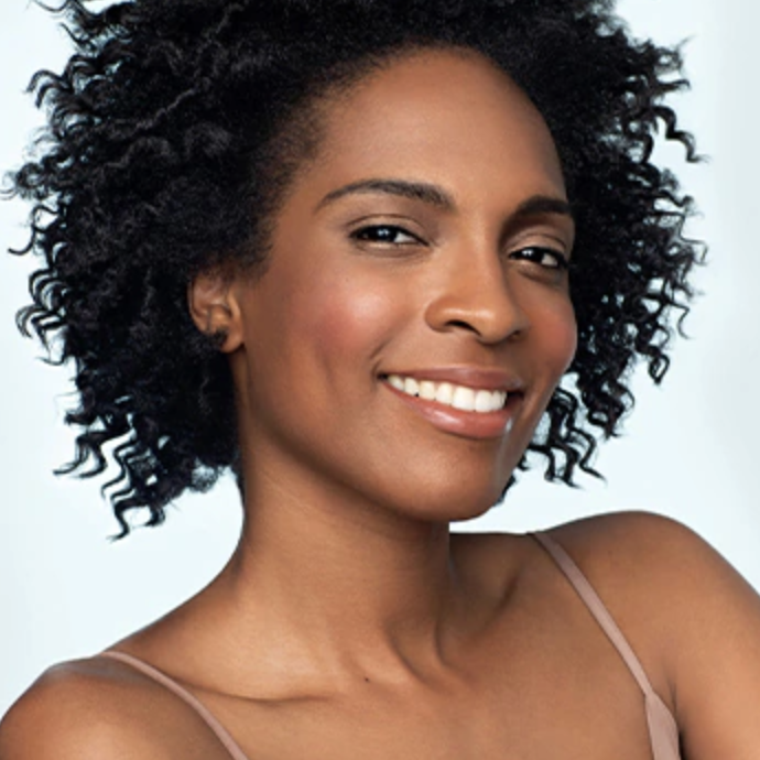 Model with shiny curls after applying the curl enhancer to their short hair