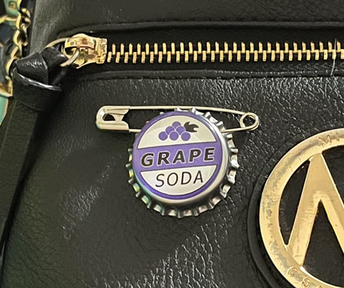 a grape soda pin attached to a handbag