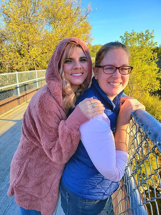 A reviewer sporting the pink hooded cardigan while standing on a bridge.