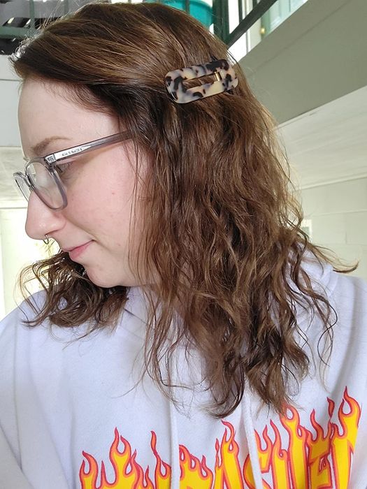 Reviewer styles their medium-length hair with a tortoise-shell rectangular clip