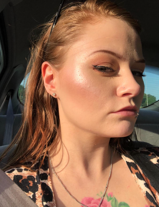 A reviewer snapping a selfie in the car, showcasing their highlighter