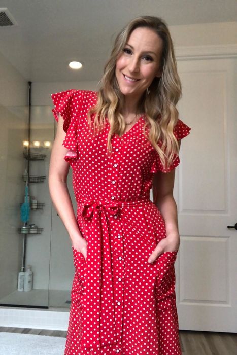 A reviewer wearing the red polka dot dress.