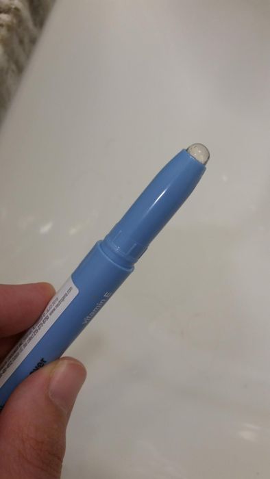 A reviewer holding the makeup-correcting stick