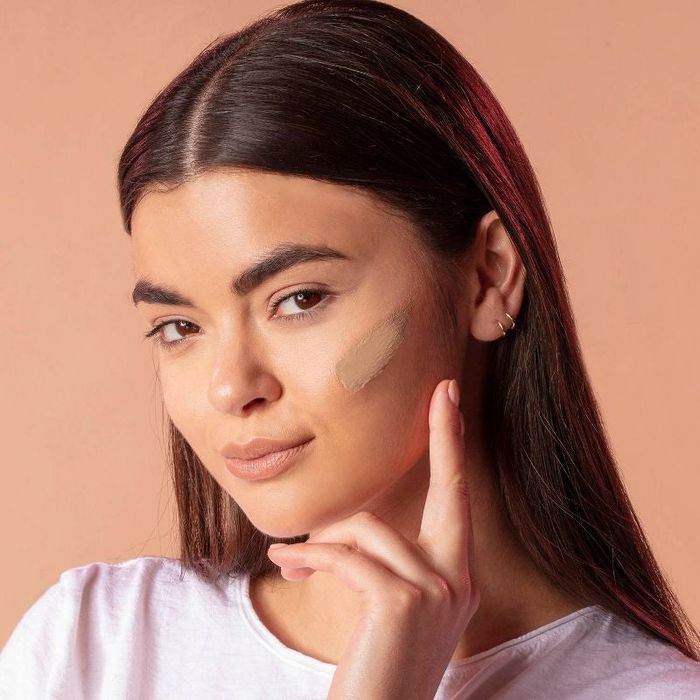 a model demonstrating the swatch of shade Medium on her face