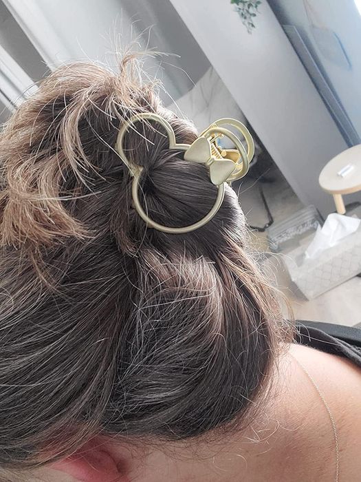 a reviewer sporting a gold Minnie Mouse-shaped clip in their hair