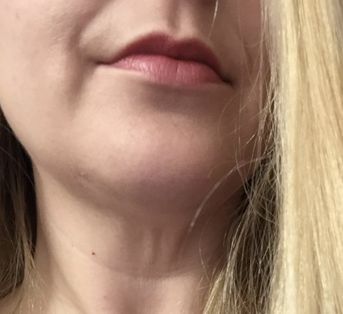 A reviewer showcases the lipstick in use, highlighting its effortless application.