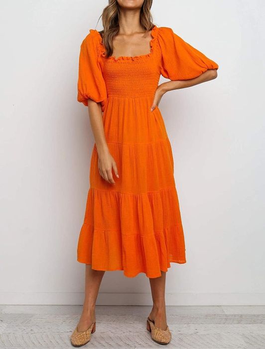 A model rocking the dress in a vibrant orange hue.