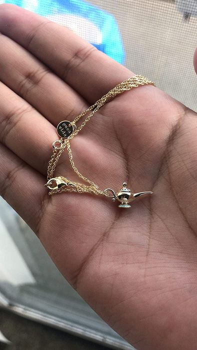 a reviewer's gold magic lamp necklace on display