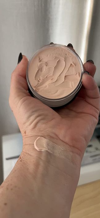 Reviewer holding the primer with a swatch of it on their wrist.