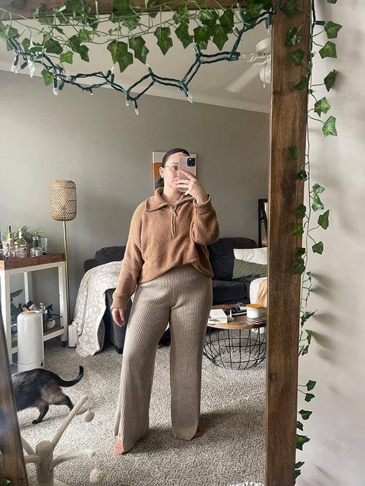 A reviewer wearing the brown pants, exuding a cozy and casual vibe.