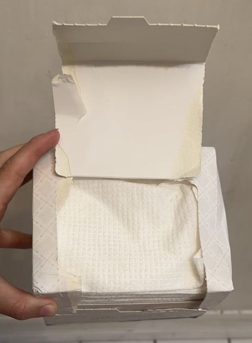A hand holding an open box.