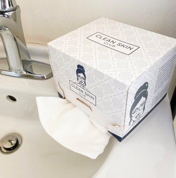 A square-shaped towel dispenser containing 50 towels
