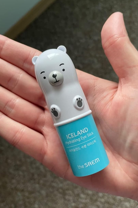 A reviewer holding the small, polar bear-shaped eye stick in their hand