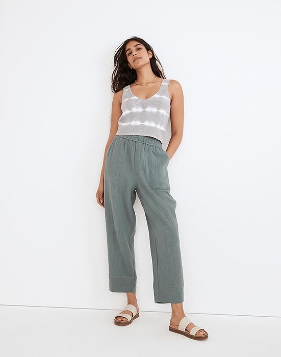 model wearing gray-blue balloon pants with a gray-and-white tank top and beige sandals