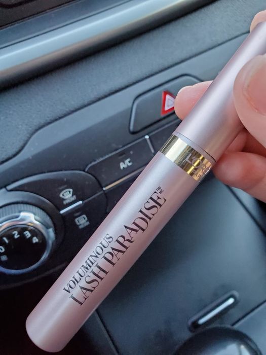 A reviewer holding up the mascara, showcasing its design and packaging.
