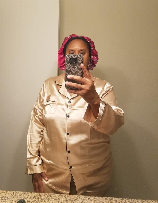 A reviewer relaxing in a beige pajama set.