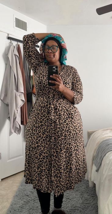 A reviewer in a brown leopard-print robe takes a mirror selfie.