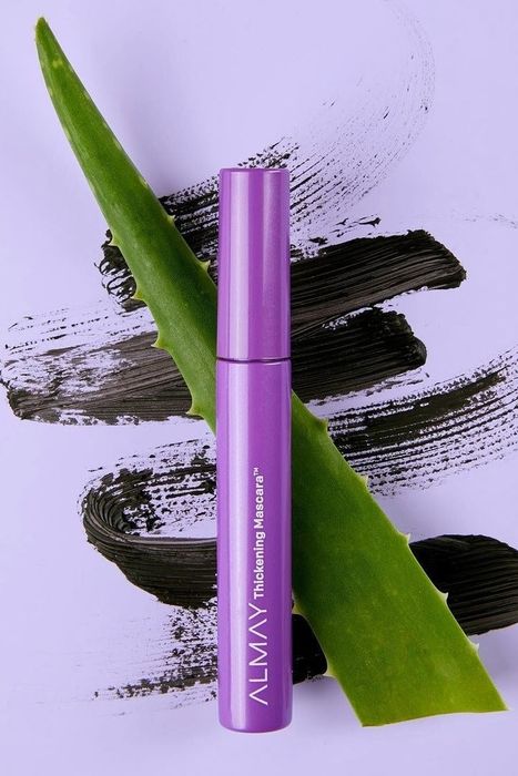 A close-up of the thickening mascara displayed next to a fresh aloe leaf.