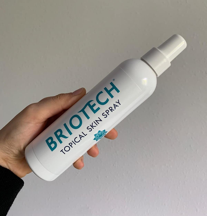 Reviewer holding their bottle of Briotech spray, ready for use