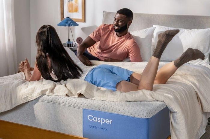 Two people unwind on a Casper Dream Max mattress in a cozy, serene bedroom setting.