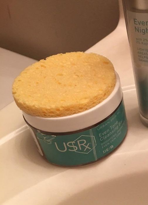 The sponge placed on top of the cleansing bar, with the product nestled inside it
