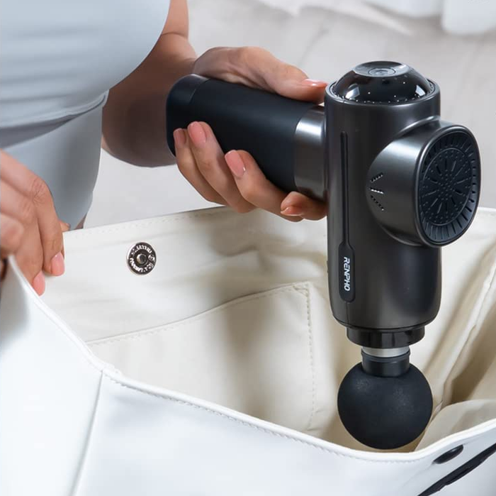 A model putting the massage gun into a tote bag