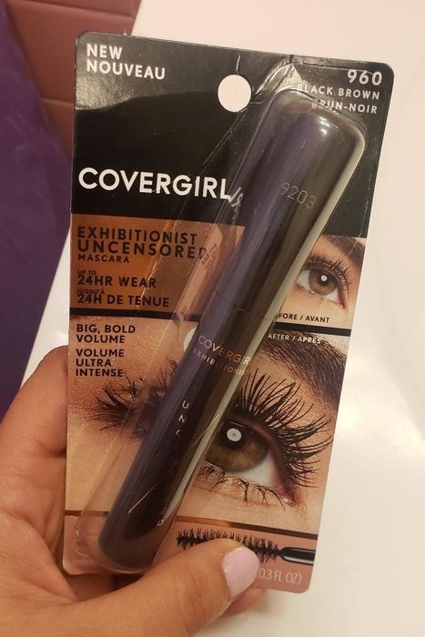 The reviewer holding the mascara tube in their hand